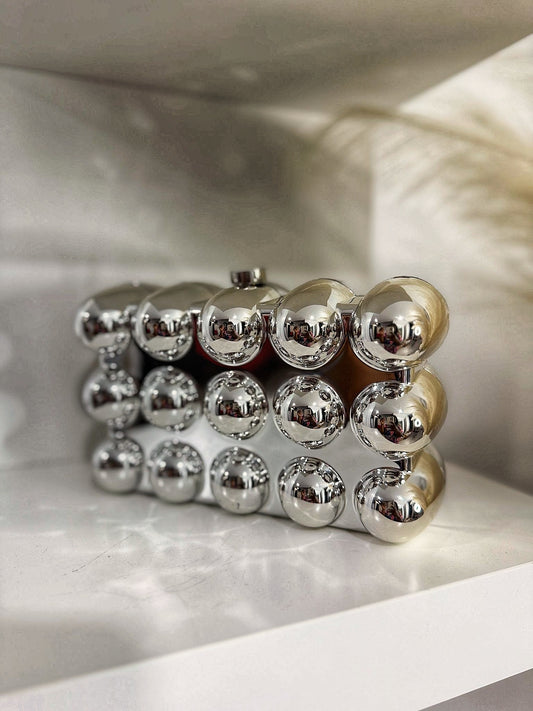Silver clutched purse adorned with metallic balls